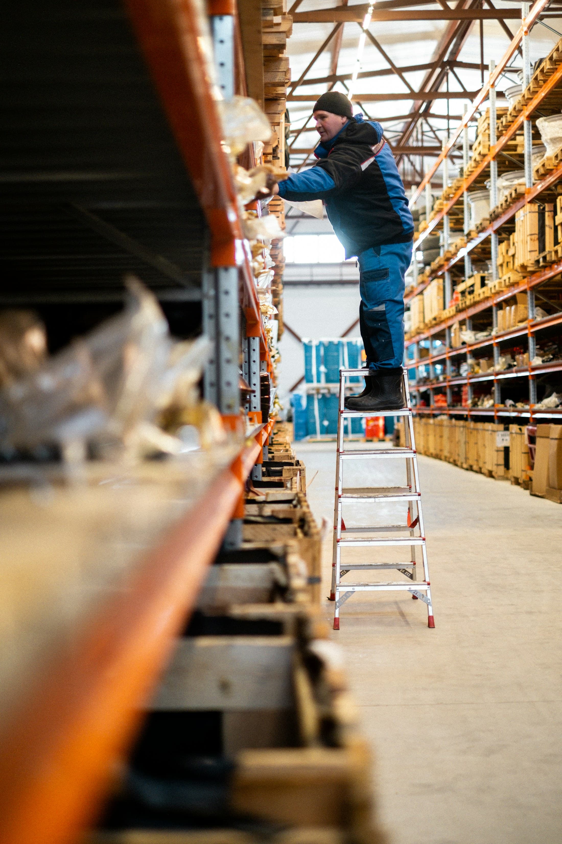 Warehouse operator checking stock on industrial shelving